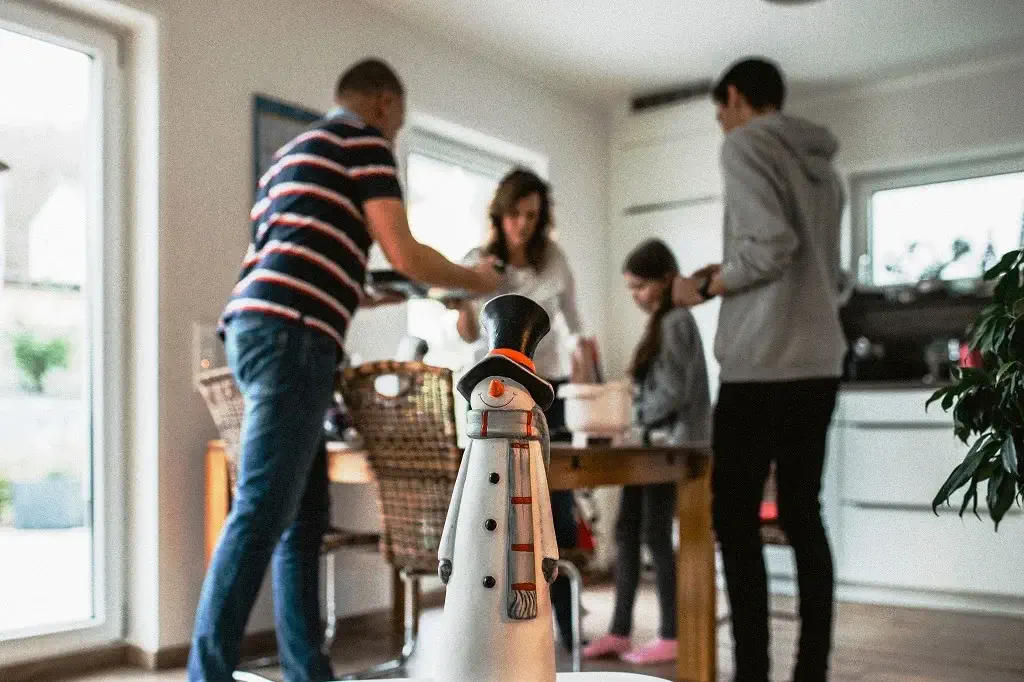 une famille qui décore un sapin de noel dans un salon