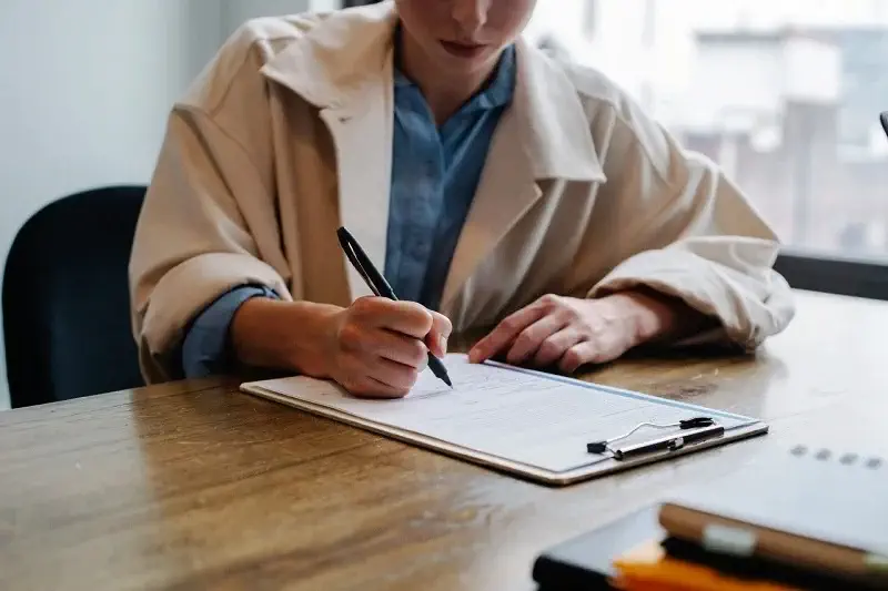 une personne qui signe un contrat entretien chaudiere